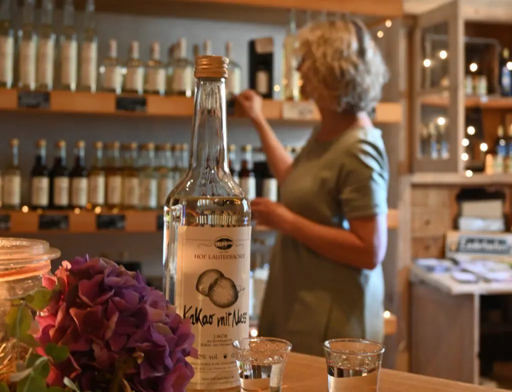 Frau Lauterbach vor einem Regal gefüllt mit Alkohol