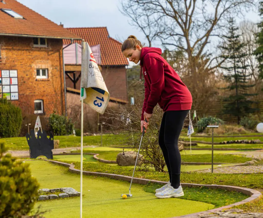 Xenia auf dem Kunstrasen um Minigolf zu spielen