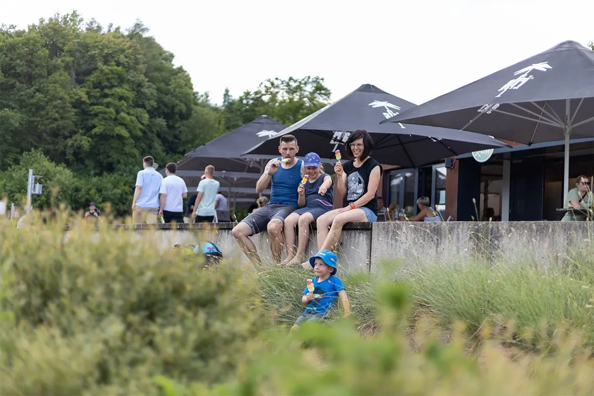 Die edlake-Familie isst ein leckeres Eis auf einer Mauer am Twistesee
