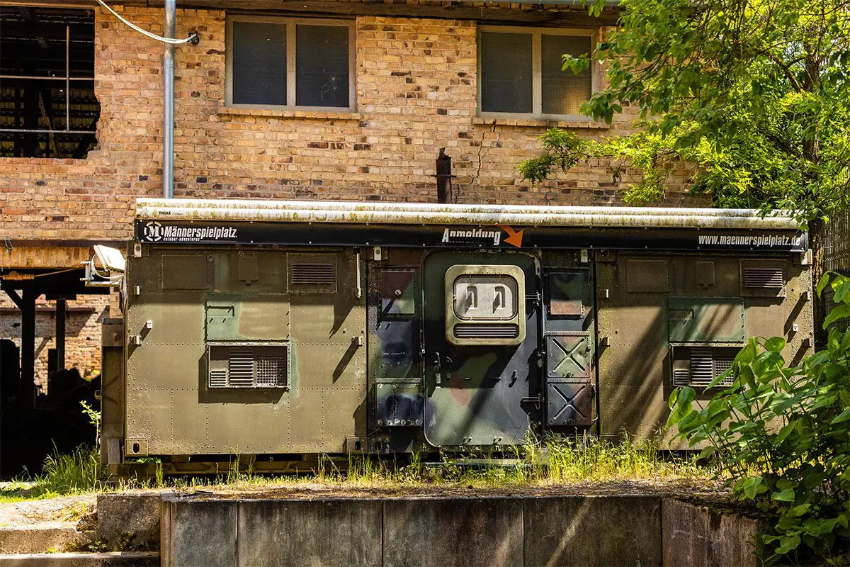 Ein alter Generator vor einer Hausfassade.