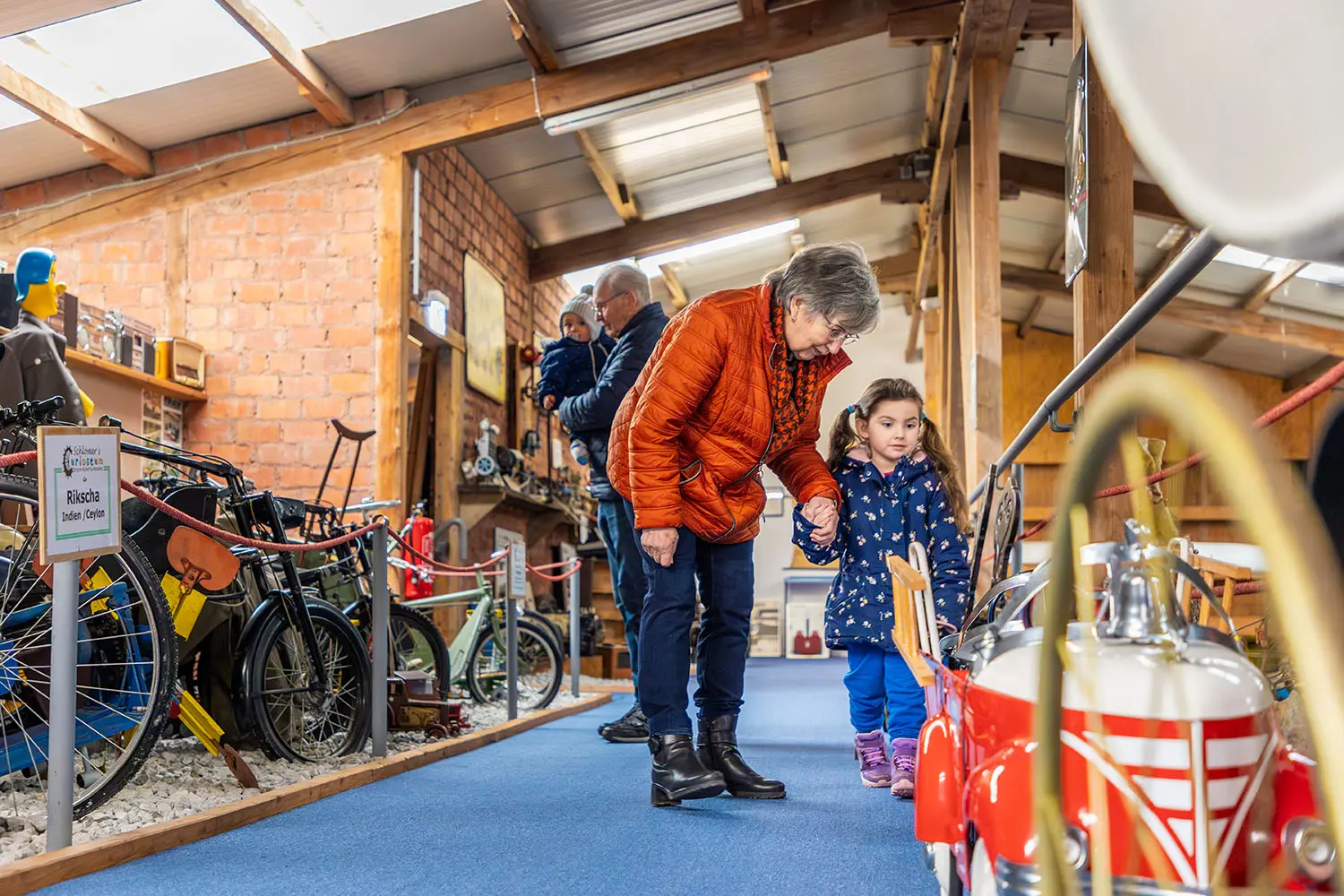 Eine Oma und ihre Enkelin sehen sich Museumsstücke an.