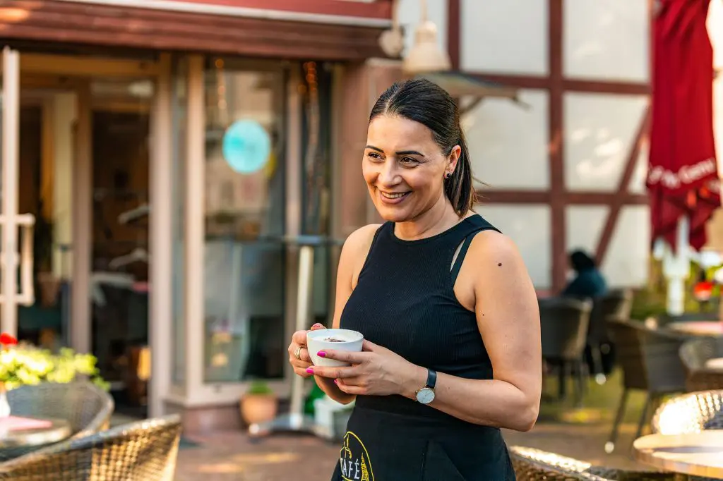 Gülay Bozkurt begrüßt die Gäste herzlich in ihrem gemütlichen Café am Kirchplatz. In dem charmanten Café duftet es nach frisch gebrühtem Kaffee und selbstgebackenem Kuchen, der liebevoll serviert wird. Foto: David Heise