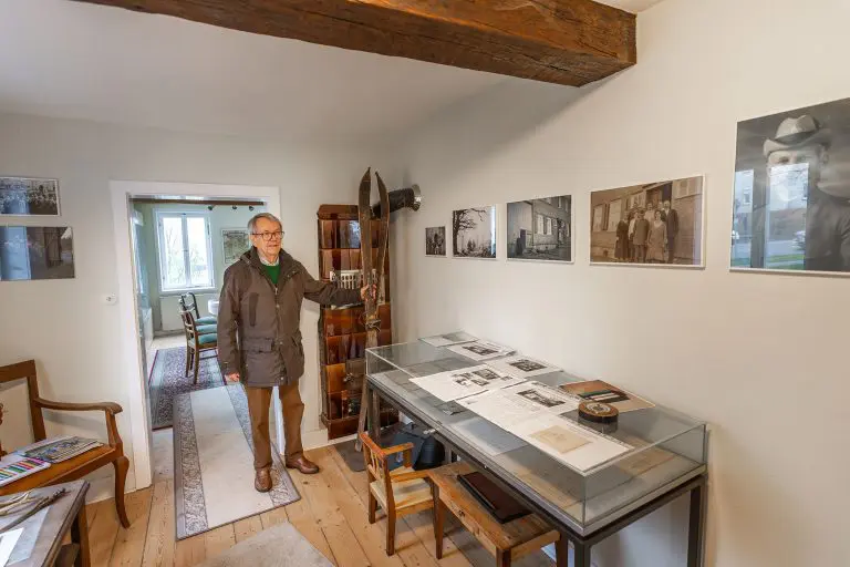 Ein Mann steht in einem Raum des Forstmuseum hundsdorf mit einem Glastisch und Bildern an der Wand. Foto: David Heise