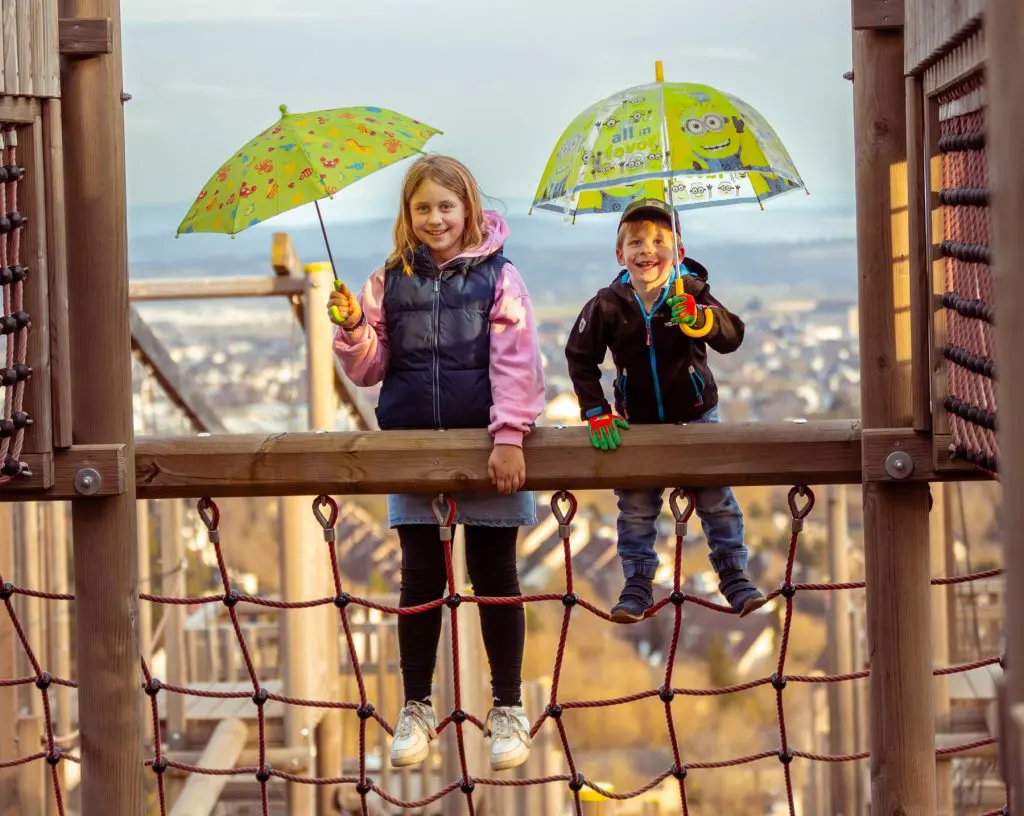 Kinder spielen auf einem Spielplatz mit der Stadt Medebach im Sauerland im Hintergrund
