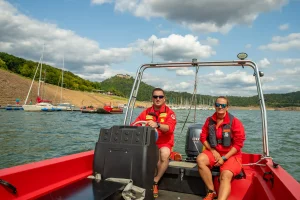 Zwei Mitglieder der DLRG Waldeck auf dem Schnellboot, welches über den See fährt. ©David Heise